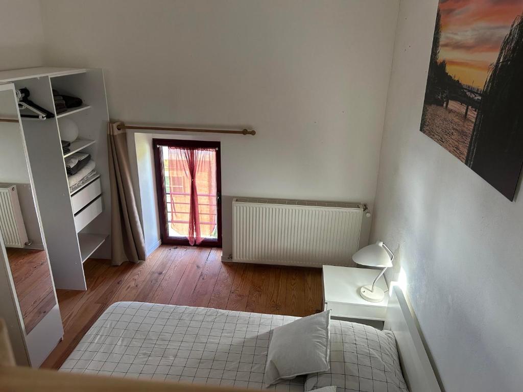 a small bedroom with a bed and a window at Le Vallon du Perche in Champeaux-sur-Sarthe