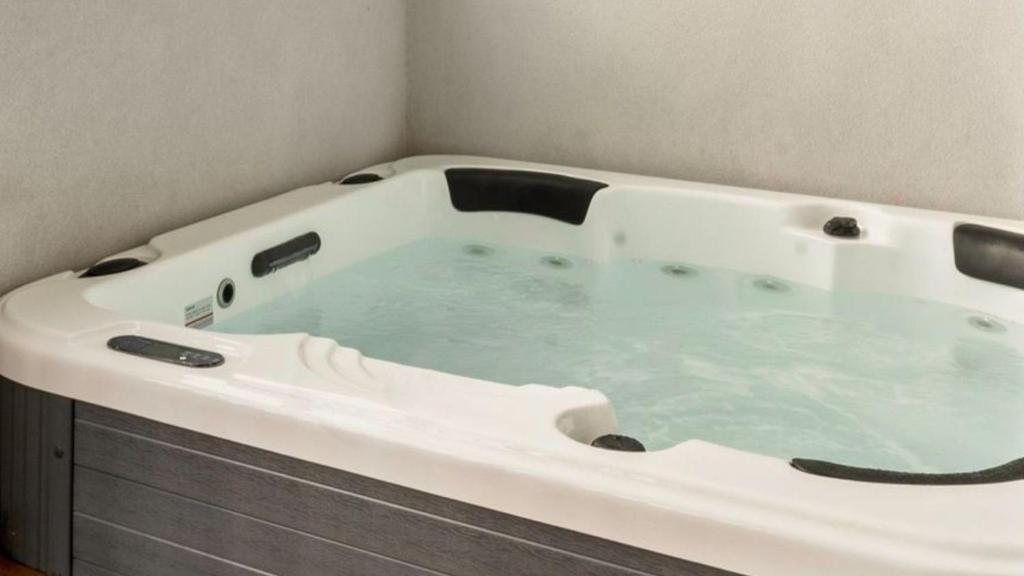 a large white bath tub in a bathroom at The Manor in Cowes