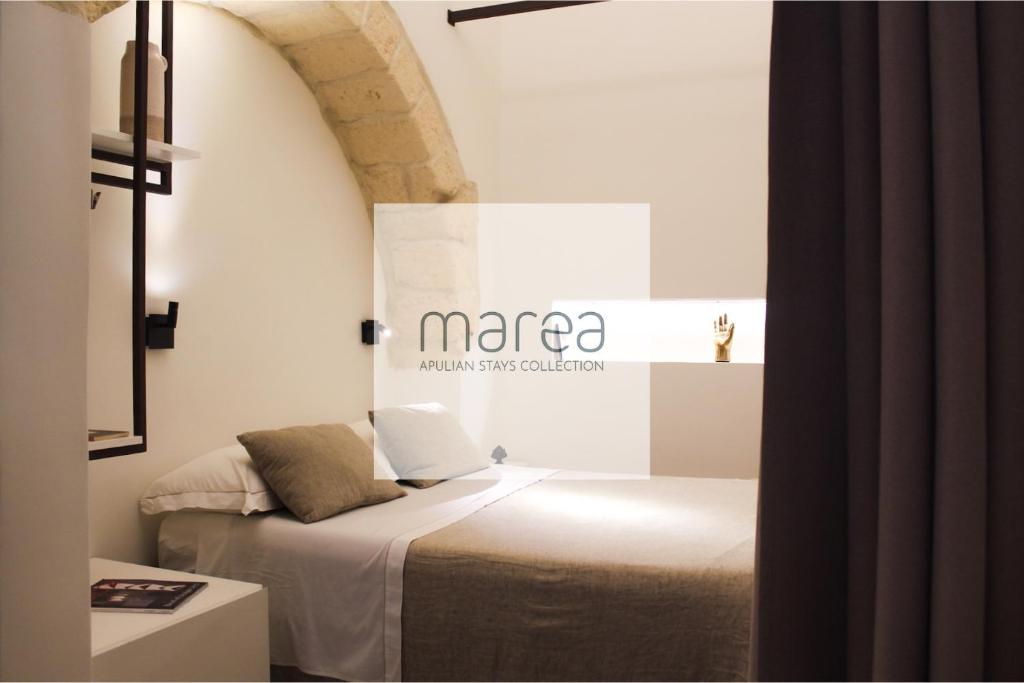 a room with a bed with a sign on the wall at I Granai - Authentic Historic House with Jacuzzi in Nardò - Marea Stays Collection in Nardò