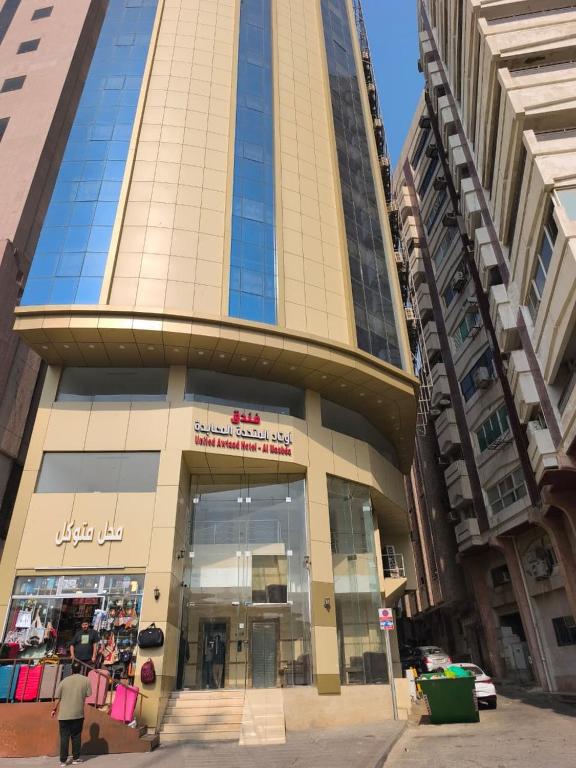 a tall building with a store in front of it at فندق اوتاد المتحدة المعابدة in An Naqāʼ