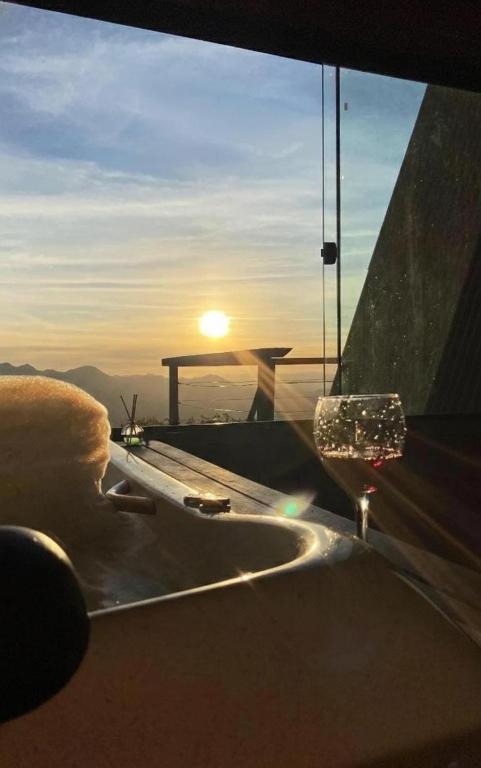 a view of the sunset from a room with a window at Chalé canaã in Passa Quatro