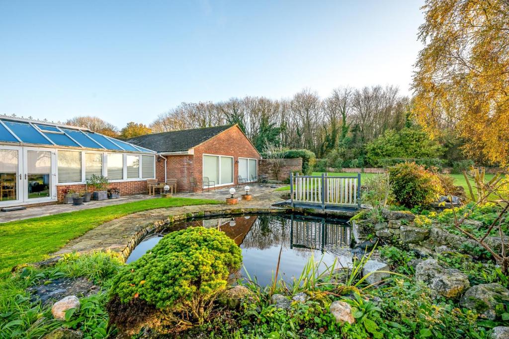 a house with a pond in the yard at Randall Farm Near Brands Hatch Circuit in Fawkham
