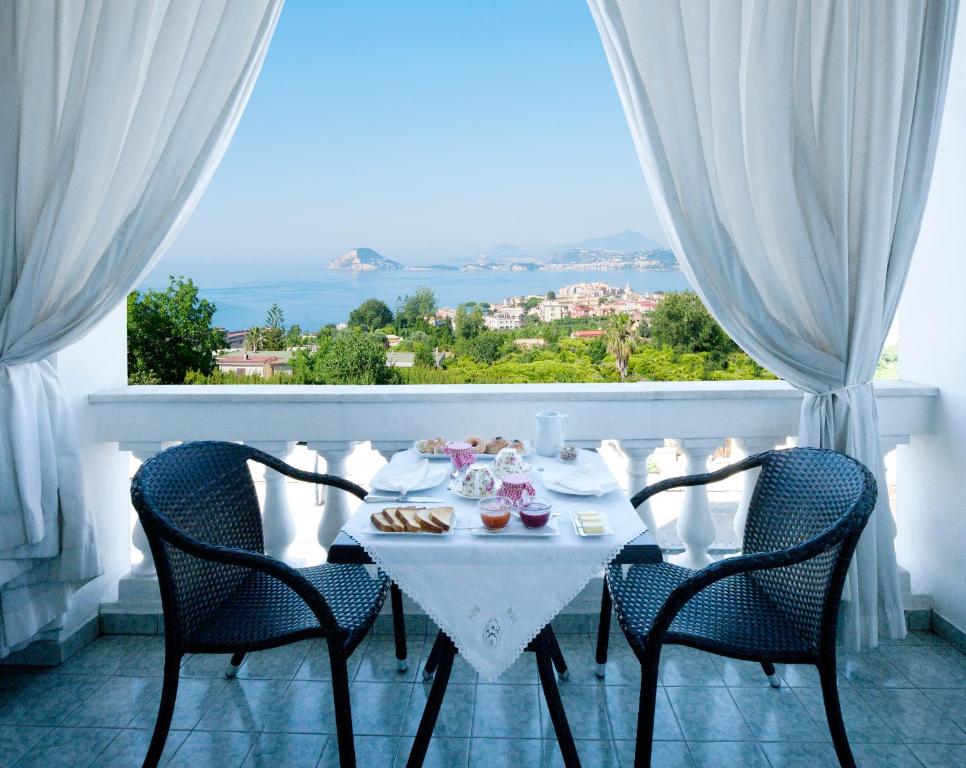 a white table with chairs and a table with food on it at B&B Dumbolo in Pozzuoli