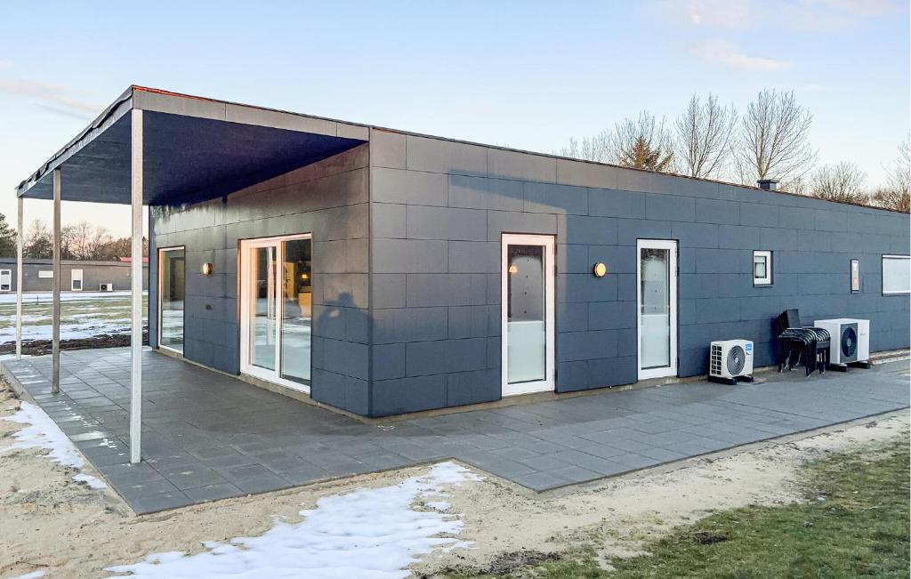 a blue building with two doors and a patio at Awesome Home In Ringkøbing With Wifi in Ringkøbing