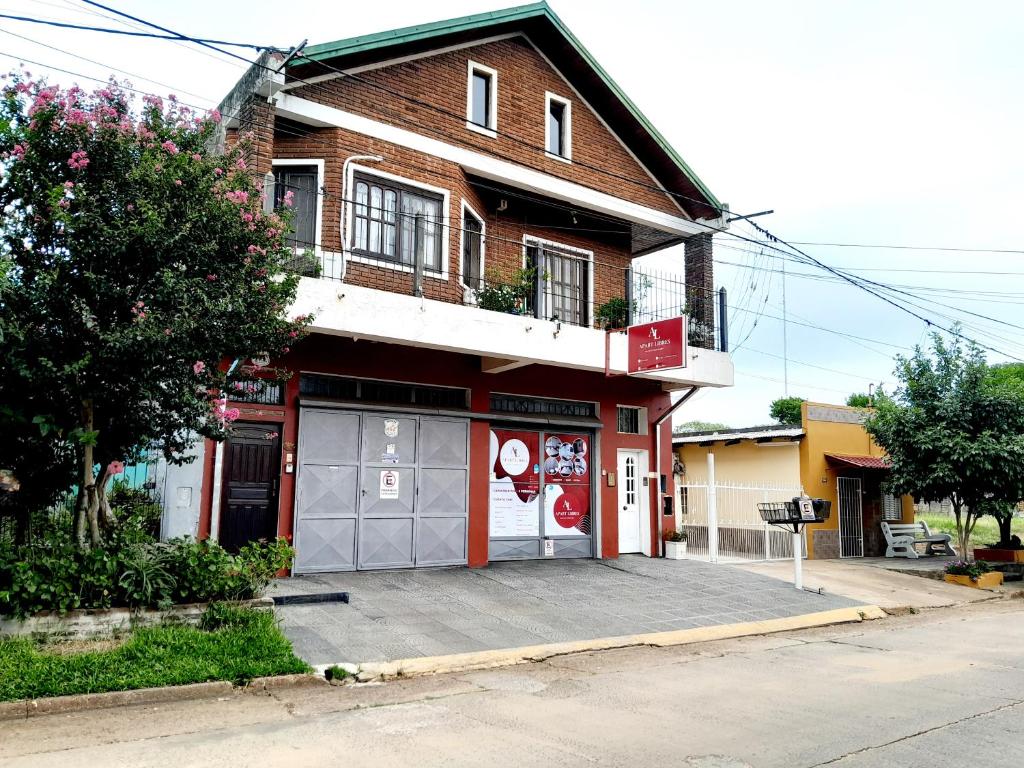 a red building with a parking lot in front of it at Alojamiento - Apart Hotel Libres - Hospedaje in Paso de los Libres