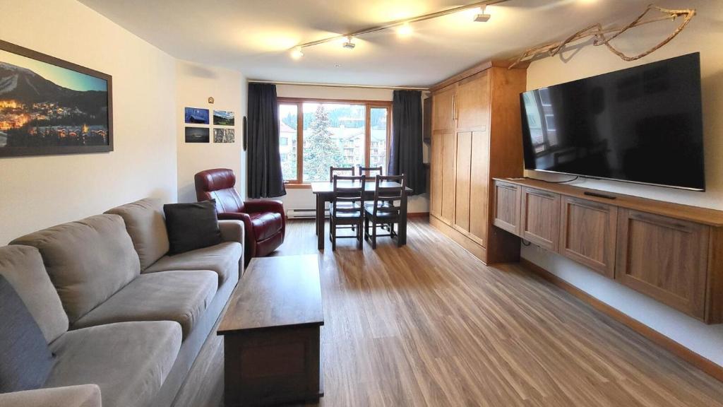 a living room with a couch and a flat screen tv at Cahilty #316 home in Sun Peaks