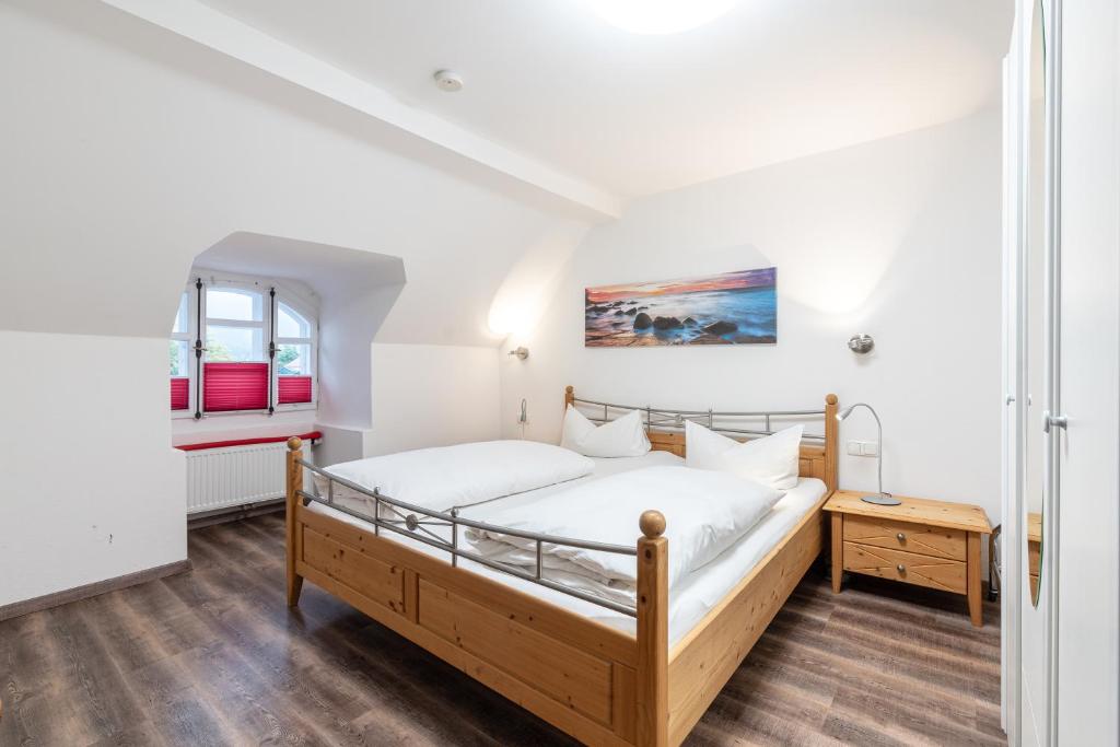 a bedroom with a bed and a window at Ferienwohnungen Ammerwinkel in Oberammergau
