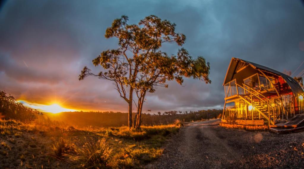 a bus driving down a dirt road at sunset at Blue Monkey Mountains in Newnes Junction