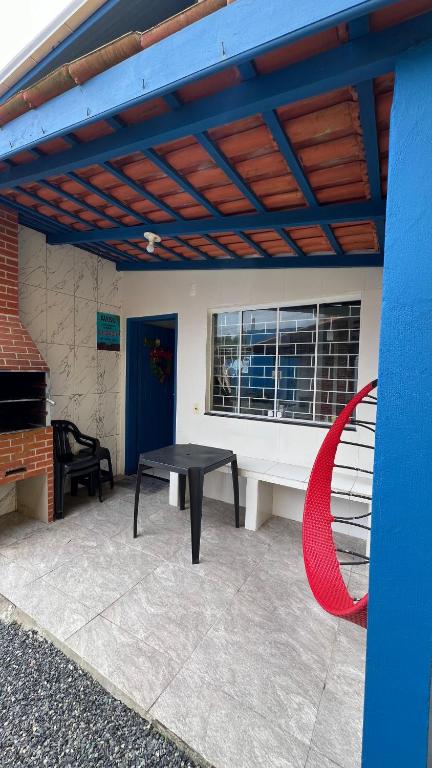 a patio with a black table and a red sculpture at PÉ NA AREIA Apto Manfron in Itapoa