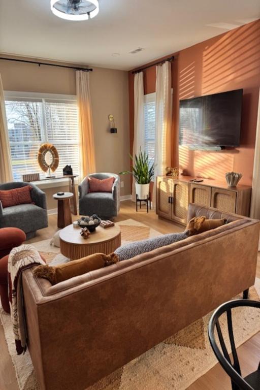 a living room with a couch and a tv at The Blue Venue-Periwinkle in Clarksville