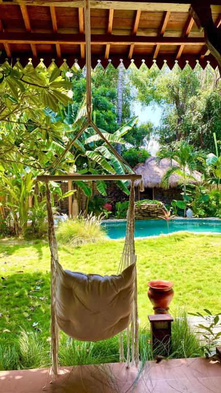 a hammock hanging from a pavilion in a garden at AMAN Villas & SPA in Gili Islands
