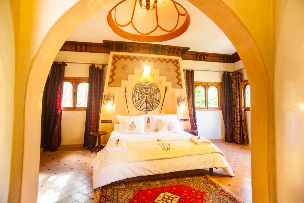 una camera con un grande letto ad arco di Riad Lamane a Zagora