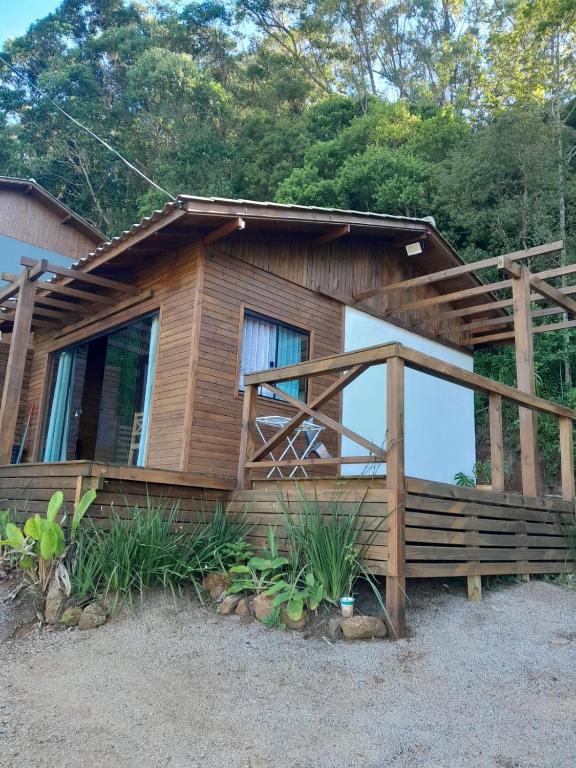 a log cabin with a porch and a deck at ResidencialBambu2 in Garopaba