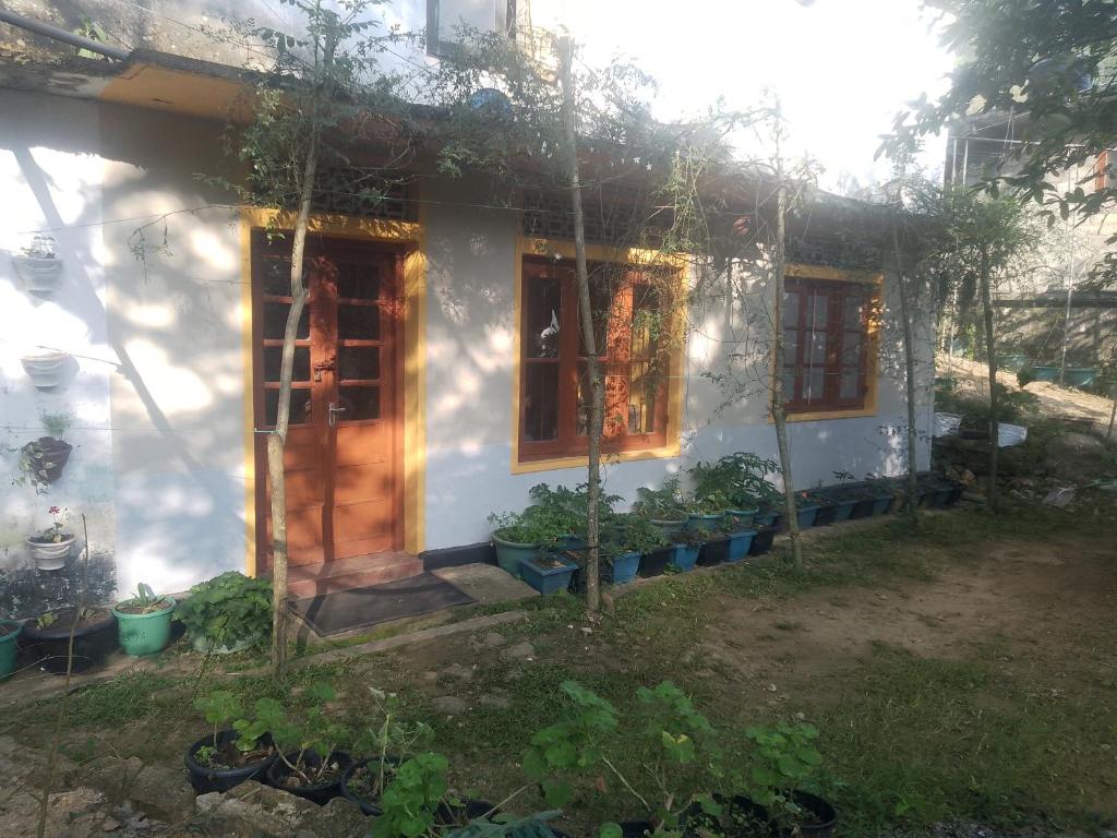 a small white house with a door and some plants at Sehandi Hotels - Renaissance Ella in Ella