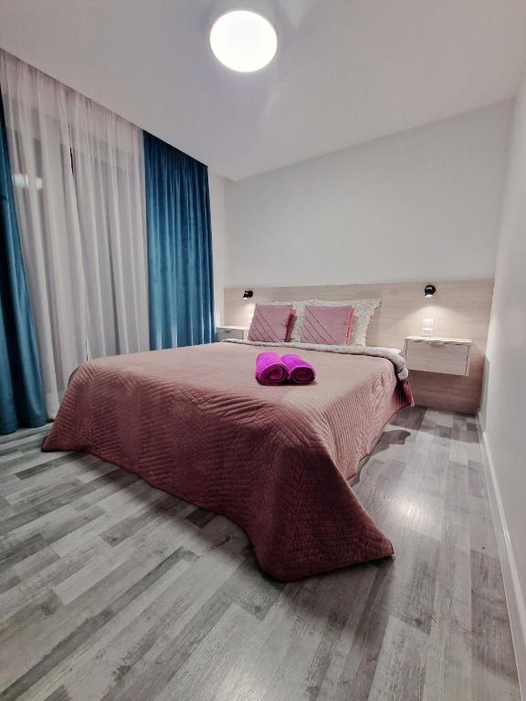 a bedroom with a large bed with two purple shoes on it at Angel in Kołobrzeg
