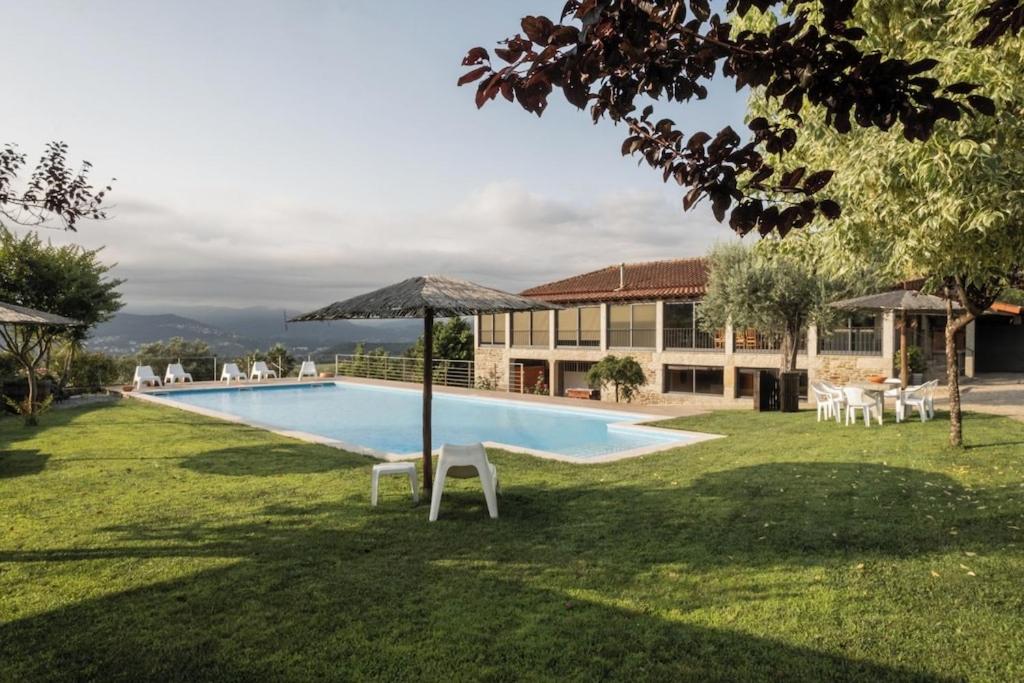 a swimming pool in the yard of a house at Quinta da Raiz in Canedo de Basto