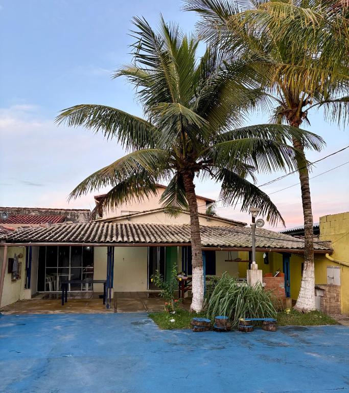 a house with two palm trees in front of it at Casa em Ilha Comprida in Ilha Comprida