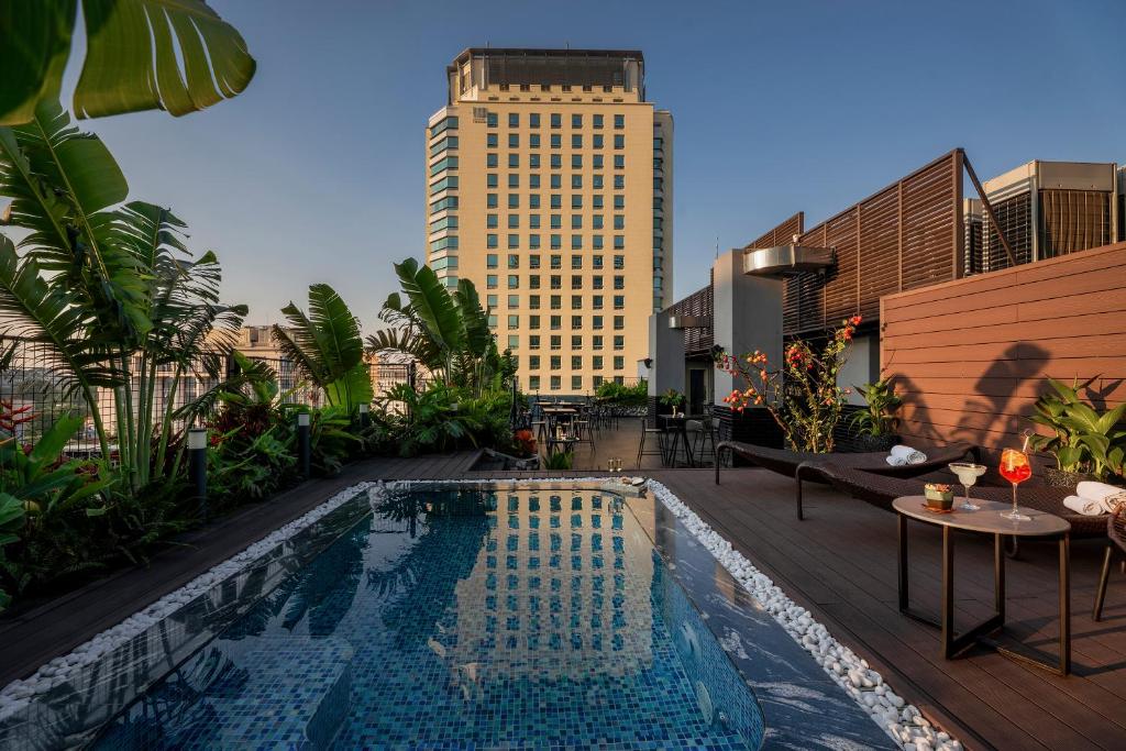 a swimming pool on a rooftop with a building at GRAND CITITEL Hanoi Hotel & Spa in Hanoi