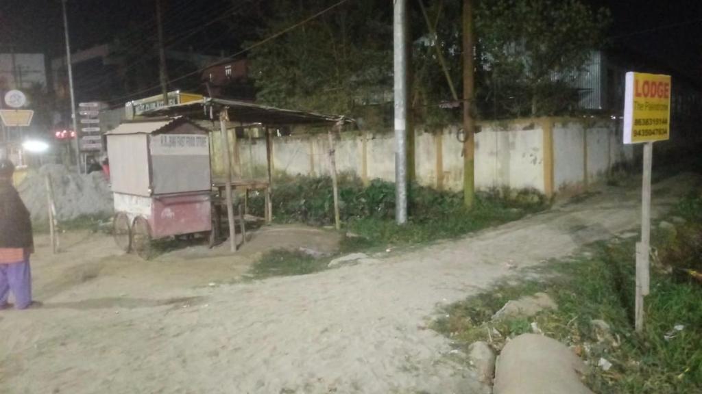 a person standing on the side of a dirt road at night at The Palindrome in Guwahati