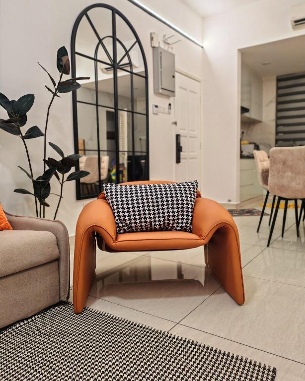 an orange chair with a black and white pillow on it at White House in Malacca