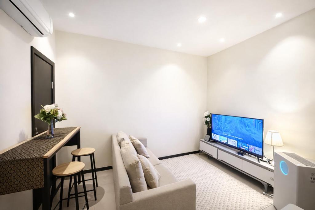 a living room with a couch and a flat screen tv at Annaz Suite Crown Pacific in Bintulu