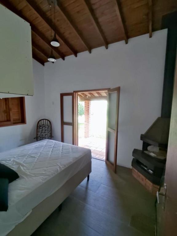 a bedroom with a bed and an open door at Sítio ou chácara in Gravataí