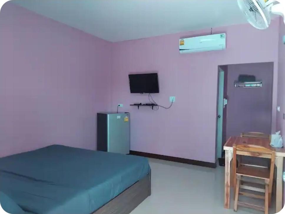 a bedroom with a blue bed and a television at K and K Resort room 1 in Prakhon Chai