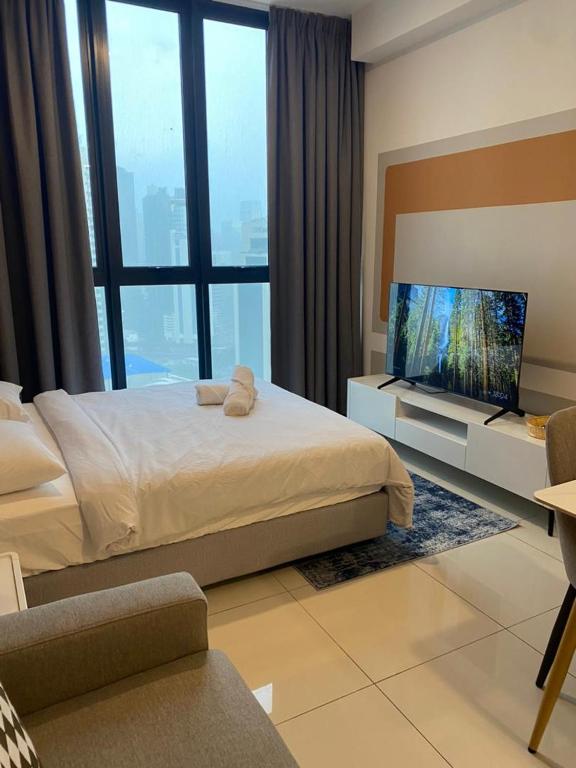a bedroom with a bed and a flat screen tv at Kampung Marsa at Majestic Residence, Kuala Lumpur in Kuala Lumpur