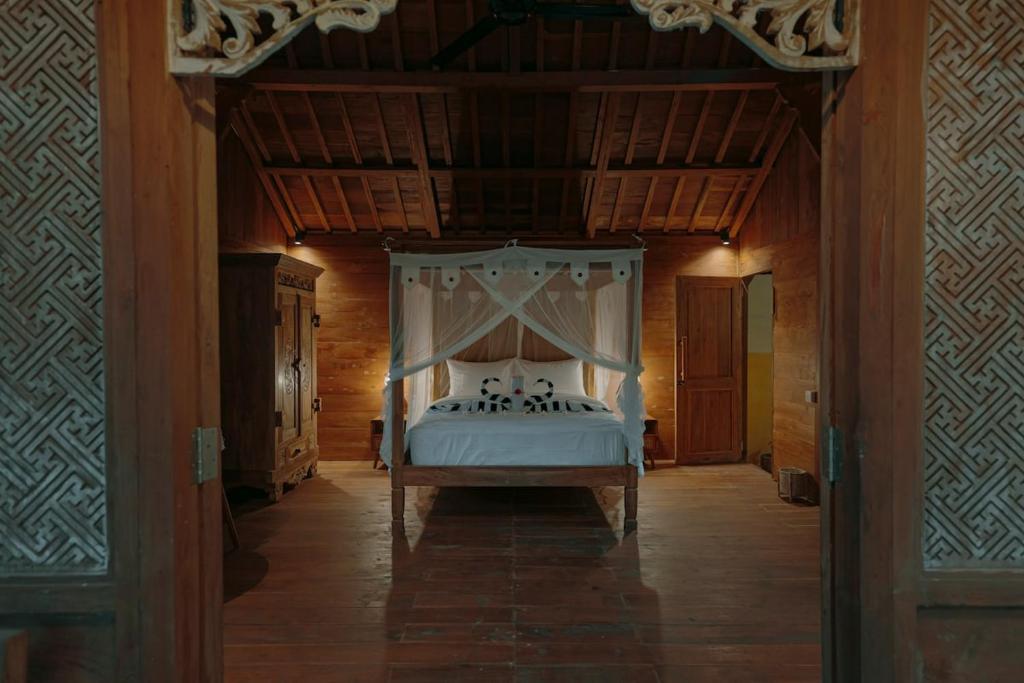 a bedroom with a bed with a canopy at Green vanilla mincung 2 in Silebeng