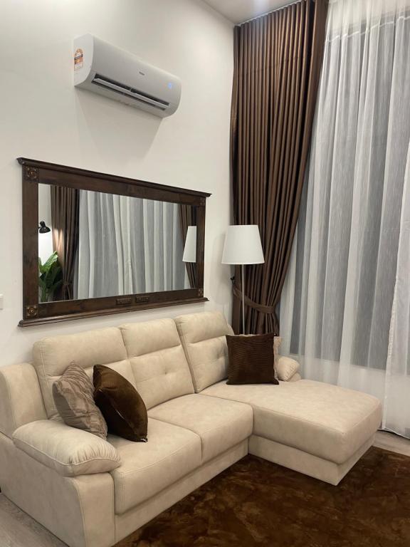 a living room with a white couch and a mirror at ResidenShals in Putrajaya