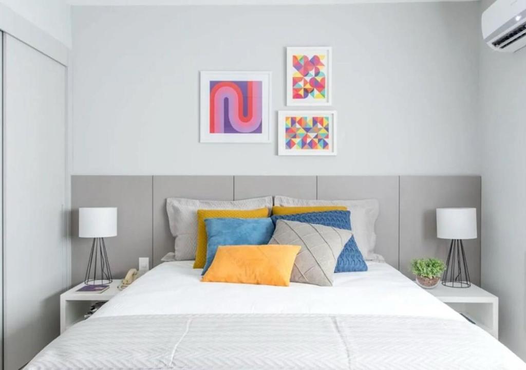 a bedroom with a white bed with colorful pillows at Loft Gracas Inn in Recife
