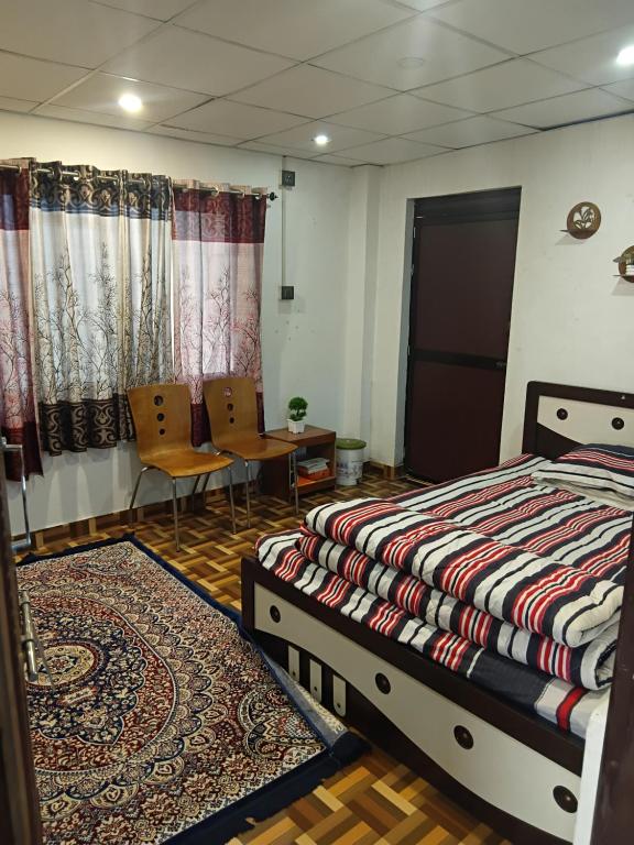 a bedroom with a bed and a table and chairs at Carkey's Staycation in Siliguri