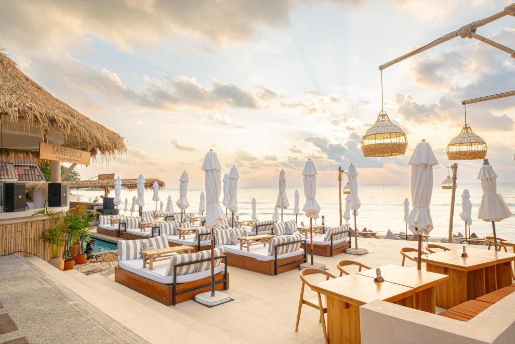 a restaurant on the beach with chairs and umbrellas at Al's Resort in Chaweng