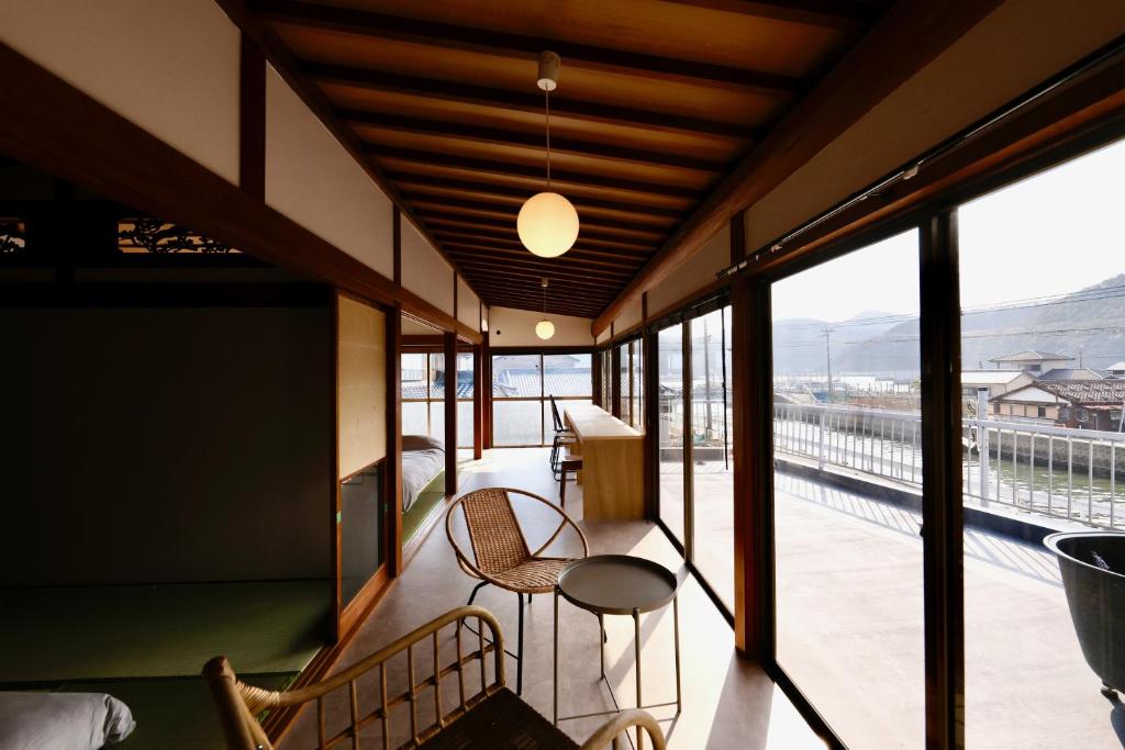 a room with a balcony with a table and chairs at RITO SAKAPORT サウナ付き一棟貸しVilla in Tsushima