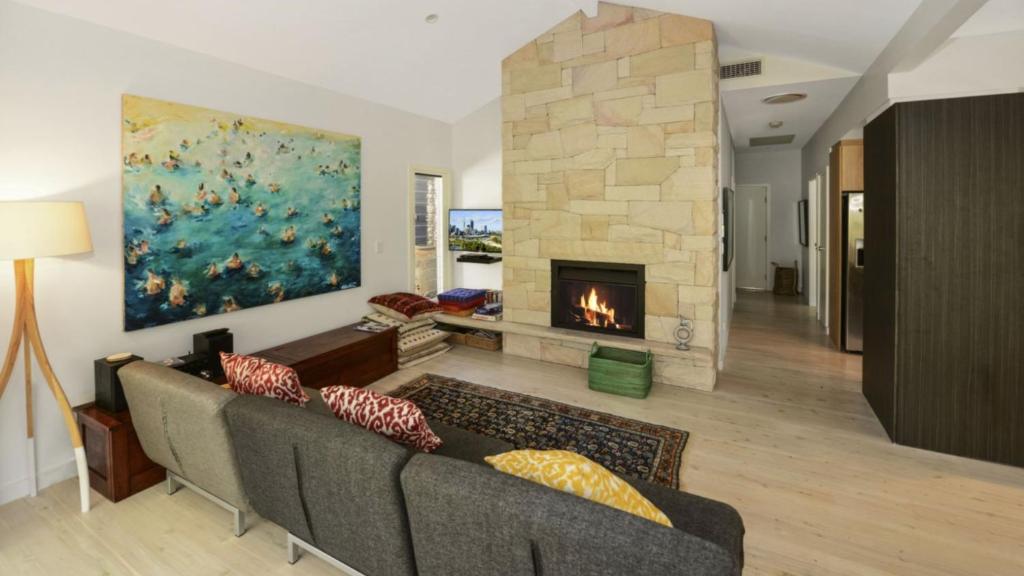 a living room with a couch and a fireplace at Mackaren's Lodge - Chic in Macmasters Beach