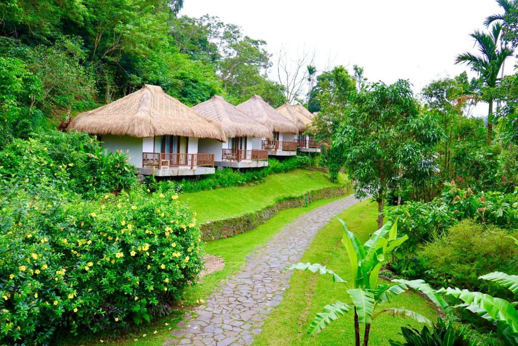 a row of huts with a path in front of them at Kelimutu Crater Lakes Ecolodge in Kelimutu
