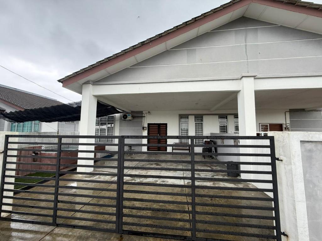 a house with a gate and stairs in front of it at Hasna Homestay Cherating Muslimonly in Kuantan