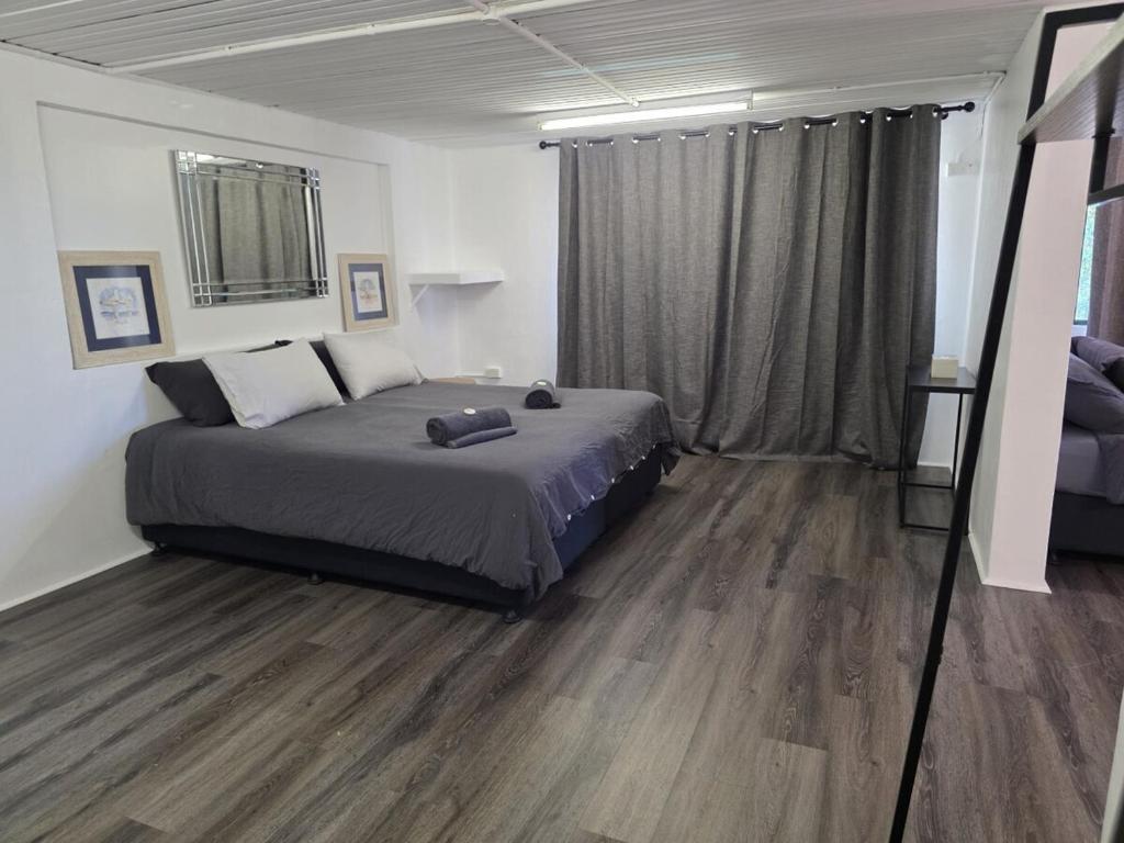 a bedroom with a bed and a wooden floor at Tranquility Studio Two in Mission Beach