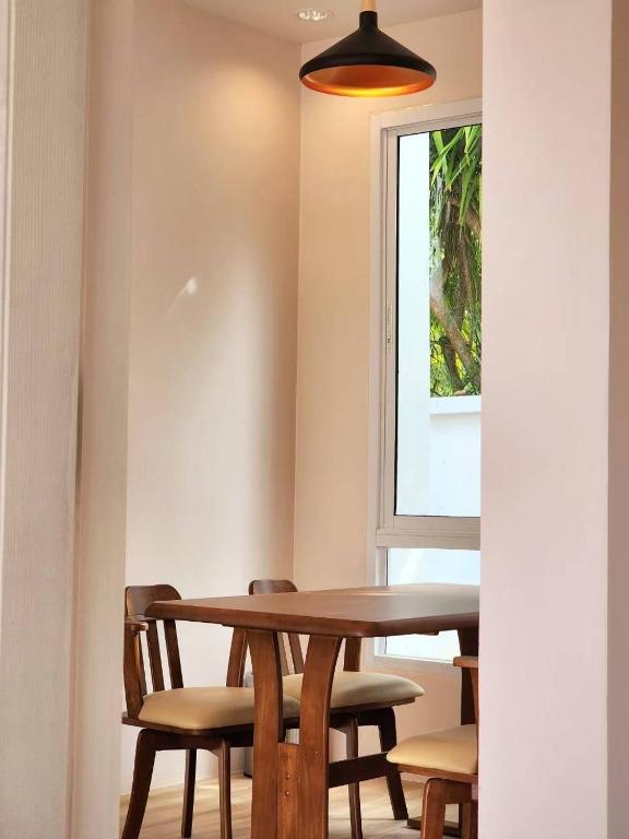 a dining room table with chairs and a window at Benjavipa Pool Villa Khao yai in Ban Nong Song Hong