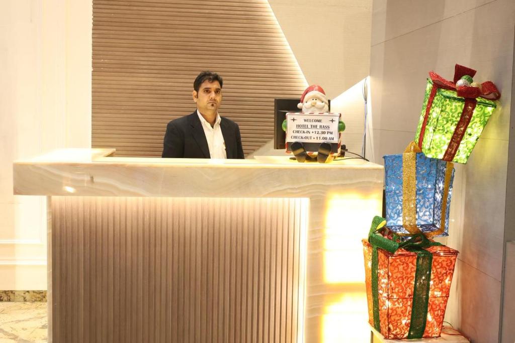 a man is sitting at a desk with presents at The Rass in Kānpur
