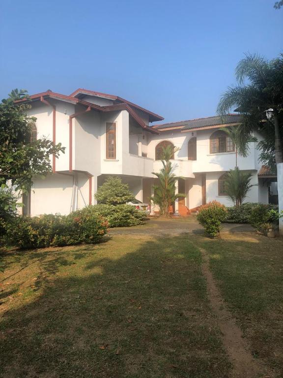 a large white house with a yard in front of it at oak yard in Nikawatawana