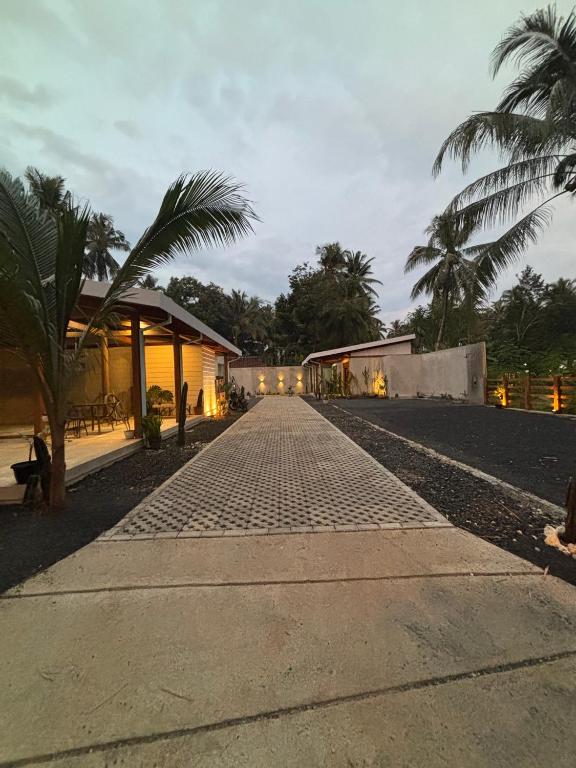 a cobblestone street with palm trees and a building at Pam's Cabin Batukaras in Batukaras