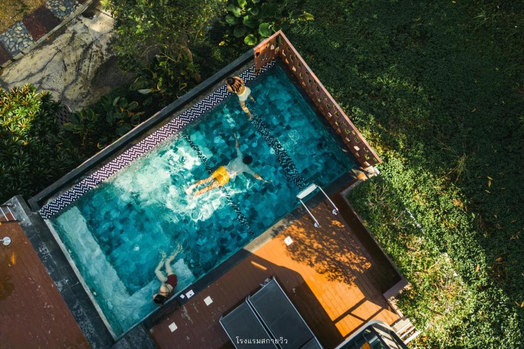 an overhead view of a swimming pool with a person in it at Sky Hill Villa SuratThani in Suratthani
