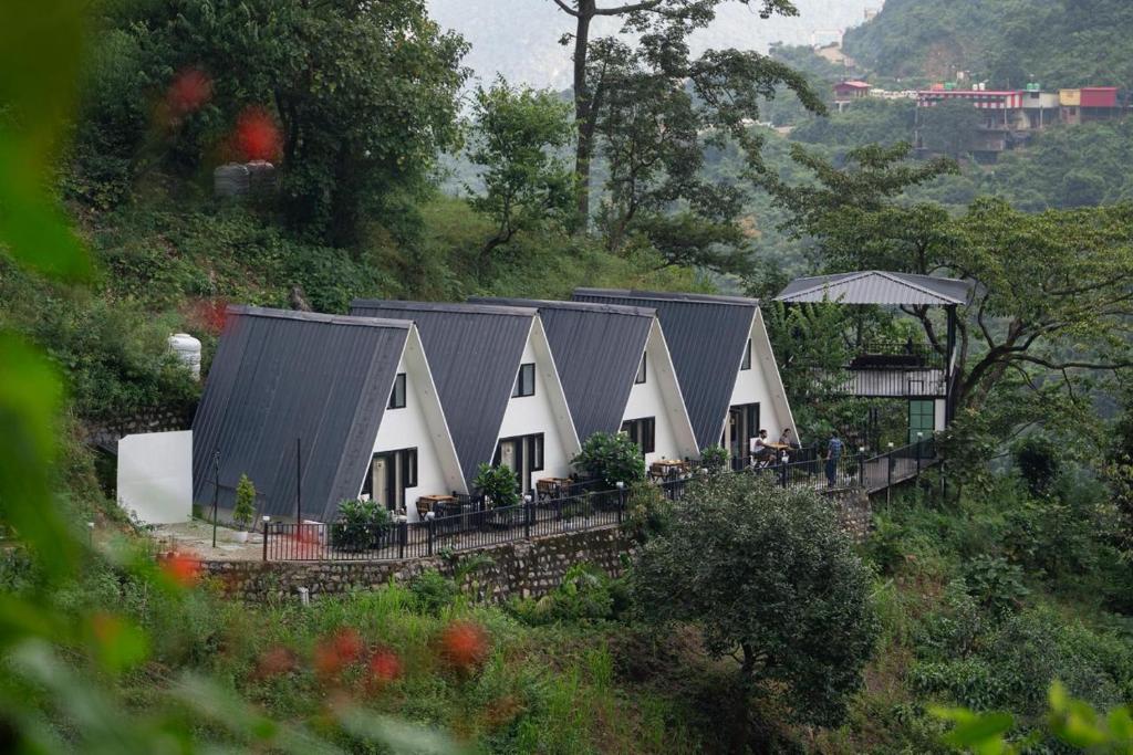 a row of houses with black roofs on a hill at The Alchemist Rishikesh in Birbhaddar