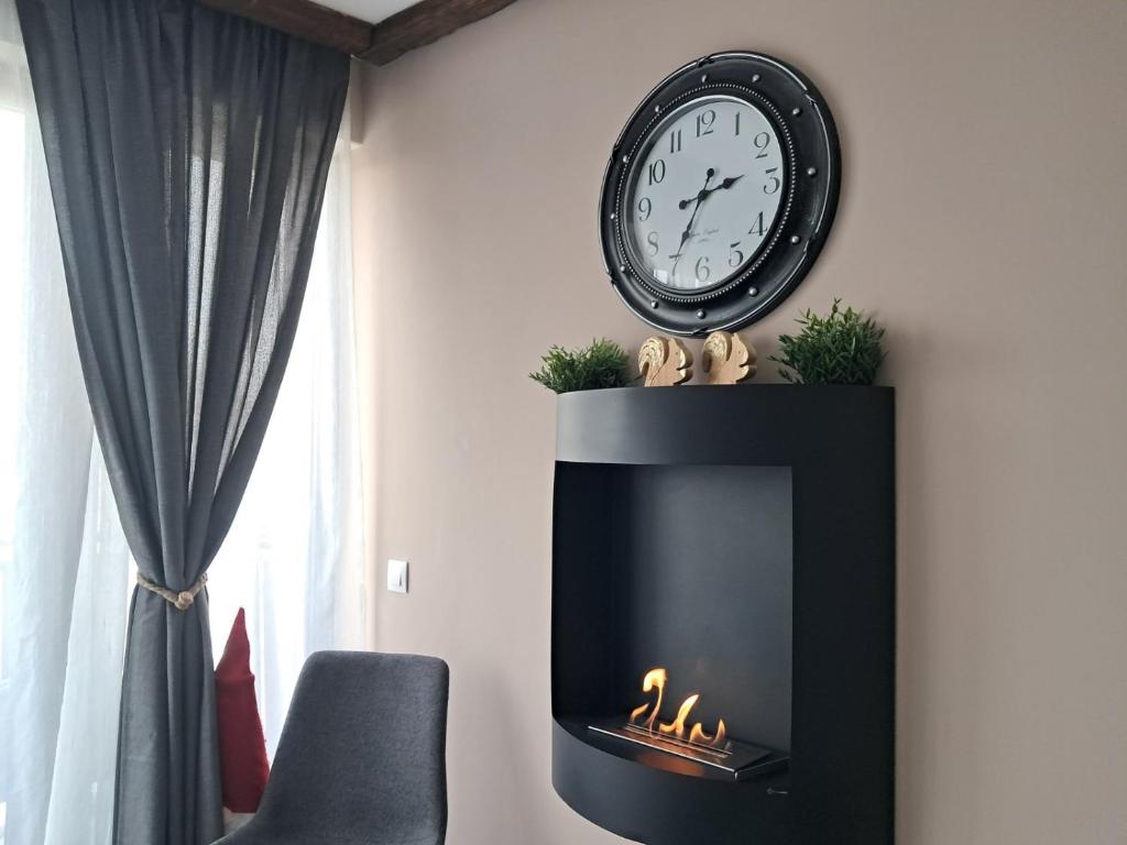 a clock over a fireplace with a clock above it at Premium StudioApartment in Borovets Gardens in Borovets