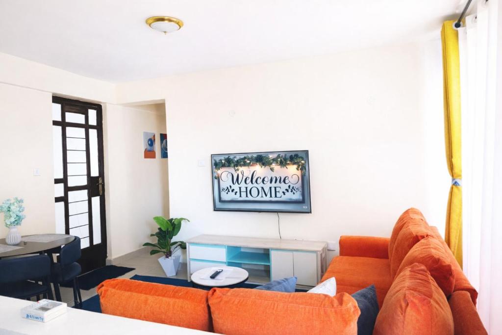 a living room with an orange couch and a table at Luxe one bedroom Kikuyu in Kikuyu