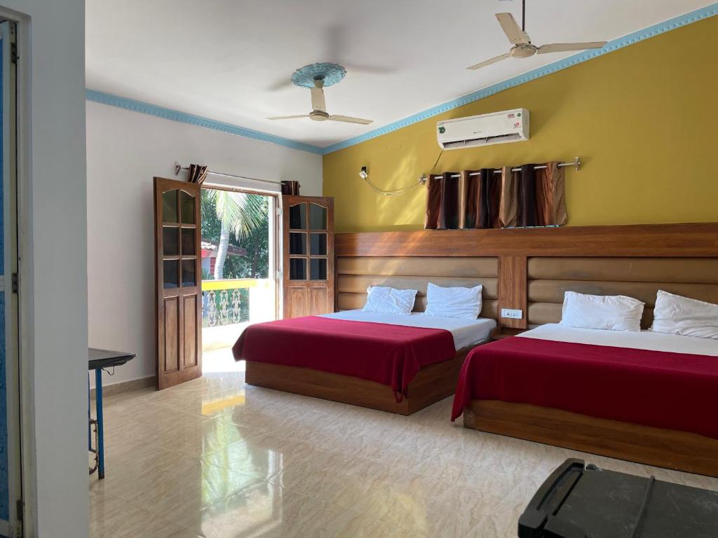 a hotel room with two beds and a window at Cardozo beach house in Calangute