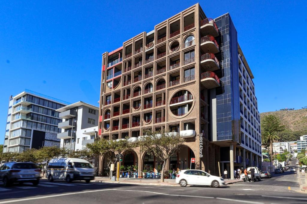 a tall building on a city street with cars at THREE43 ON B - Fluent Serviced Apartments in Cape Town