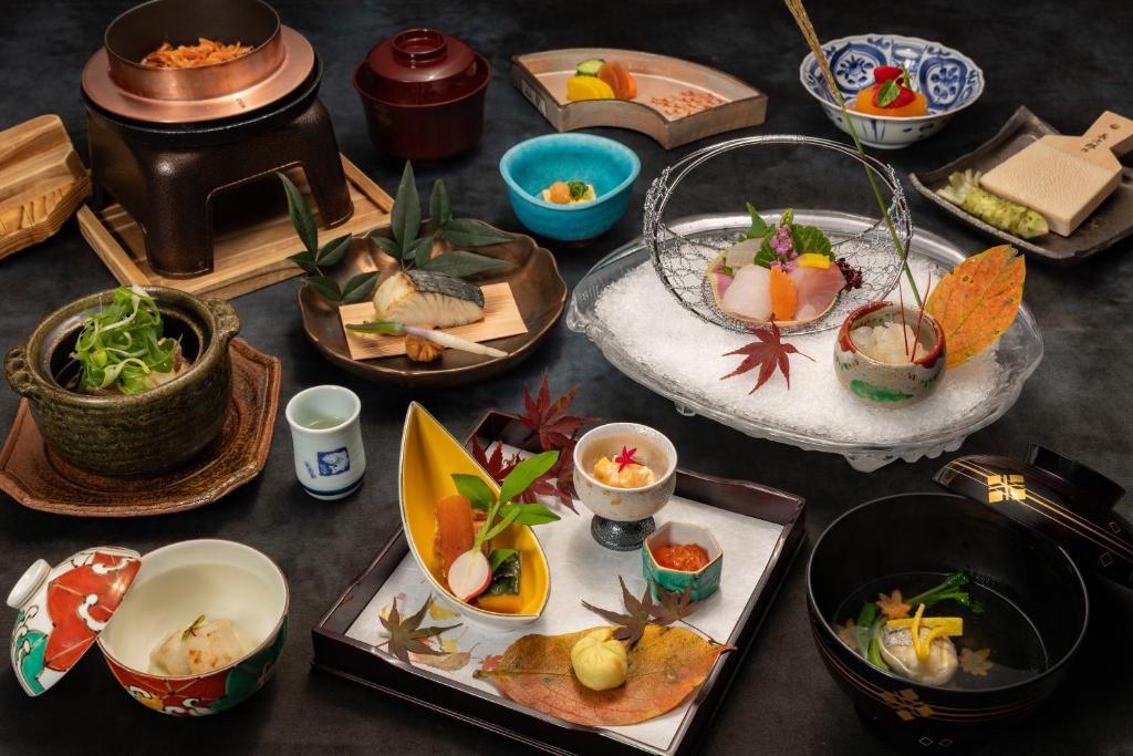 une table avec de nombreuses assiettes de nourriture dessus dans l'établissement ABBA Resorts Izu - Zagyosoh, à Itō