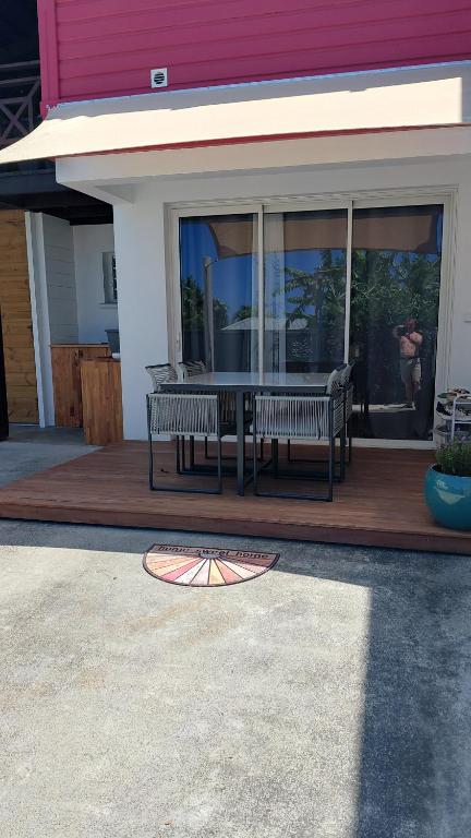 a patio with two benches and a table on a house at bambou studio in Les Avirons